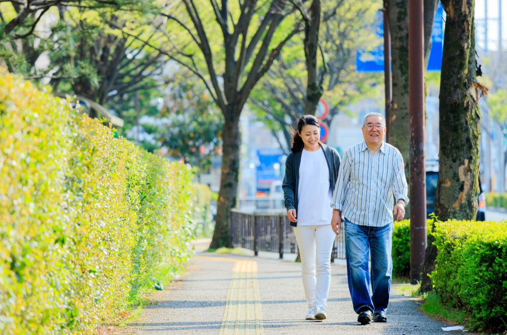 ヘルパーと一緒に歩道を散歩するシニア