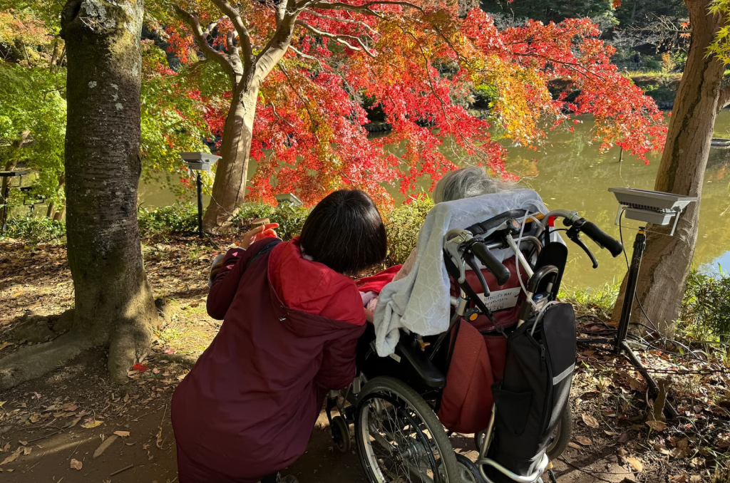 車いすの方と紅葉を観に行く親子