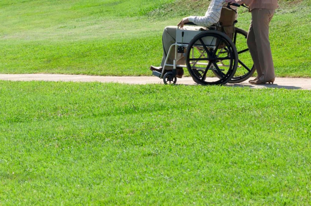 ヘルパーさんが高齢者の車いすを押す様子